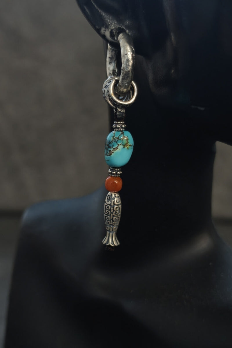 modello-indossa-orecchino-singolo-pesce-sacro-stile-asimmetrico