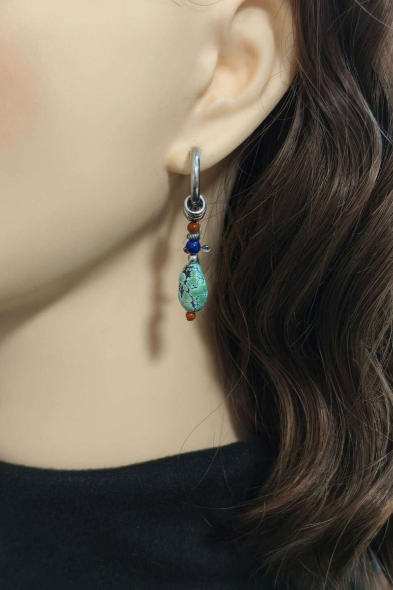 modello-indossa-orecchino-singolo-croce-turchese-asimmetria