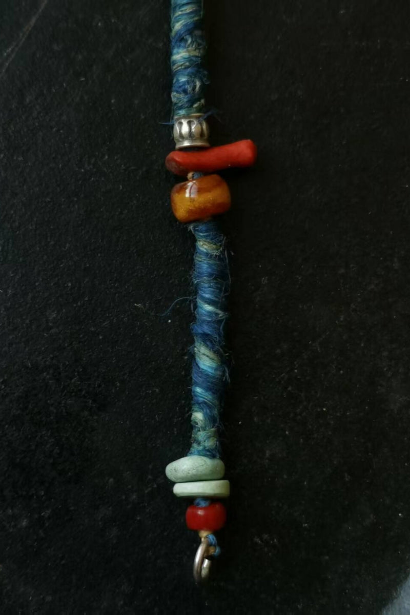 primo-piano-turchese-corallo-agata-argento-su-canapa-blu