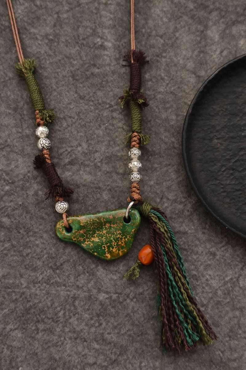 collana-turchese-orizzontale-scaglia-38mm-corda-intrecciata-grani-argento-nappa-corallo-vista-frontale