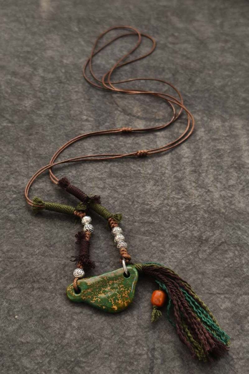 "Sospeso" | Collana con Scaglia di Turchese Orizzontale, Corda Tibetana Intrecciata, Grani d'Argento Incisi e Nappa con Corallo - Gioiello Artigianale dal Movimento Eolico